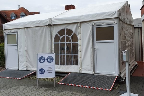 Mobiles Testzelt mit zwei Eingängen und Hinweisschild „Bitte betreten Sie einzeln! Danke“